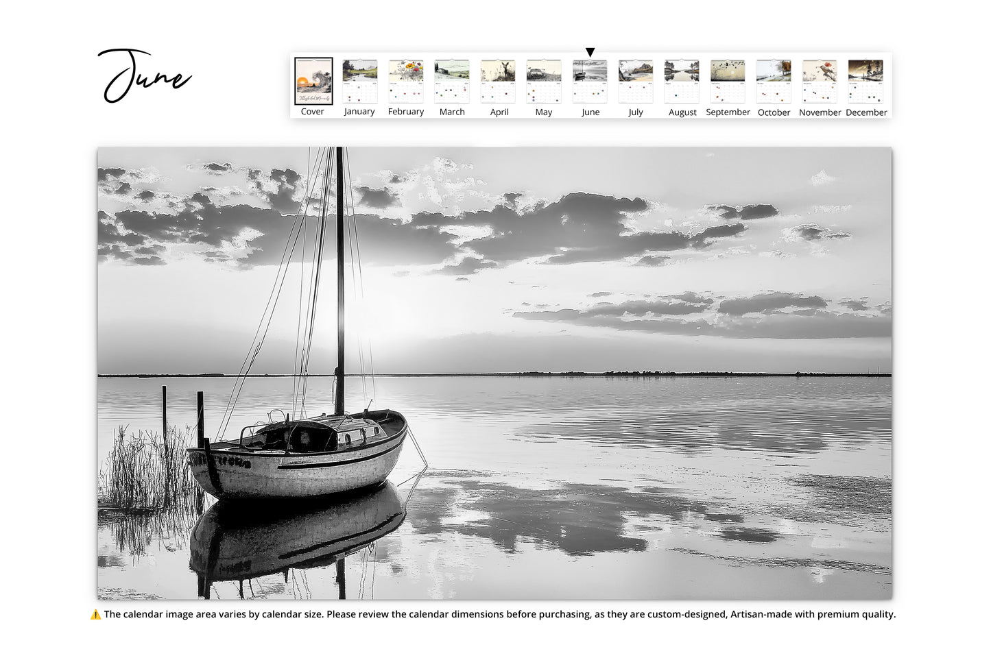 June page of the "Illustrated Moments" calendar showcasing a reflective black-and-white landscape of a sailboat moored on a calm body of water with dramatic cloud formations above.