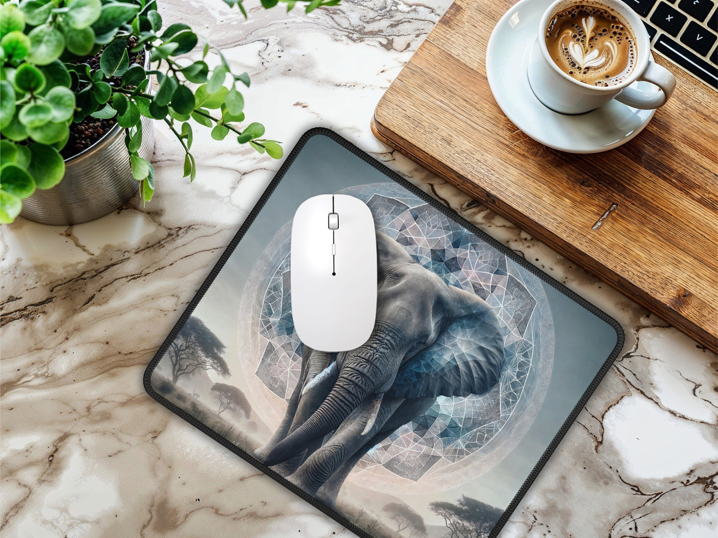 Desk setup with marble background, featuring the elephant mouse pad, a white mouse, and a cup of coffee.