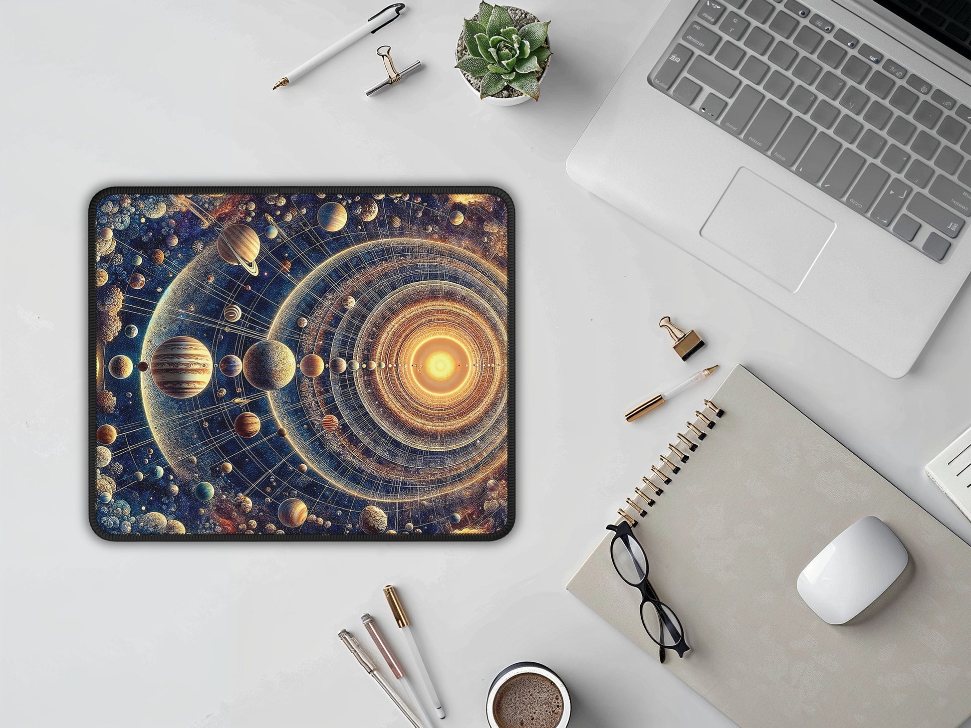 The mouse pad lies on a modern desk, surrounded by office supplies, with its mesmerizing galactic print complementing the white mouse and laptop.