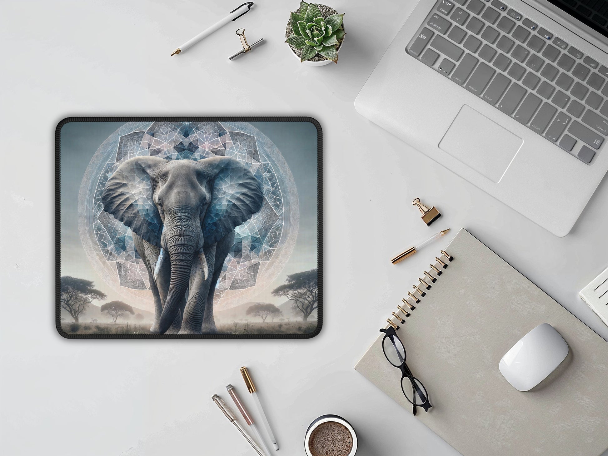 Elegant workspace with laptop, notebook, and the kaleidoscope elephant mouse pad, blending technology with art.