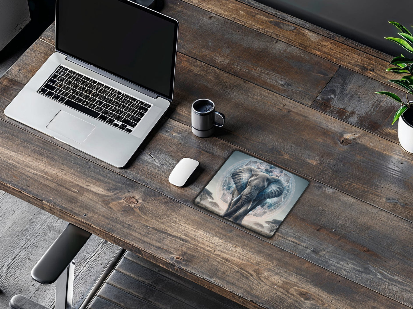 Rustic wooden desk featuring the artistic elephant mouse pad, a laptop, and office essentials.