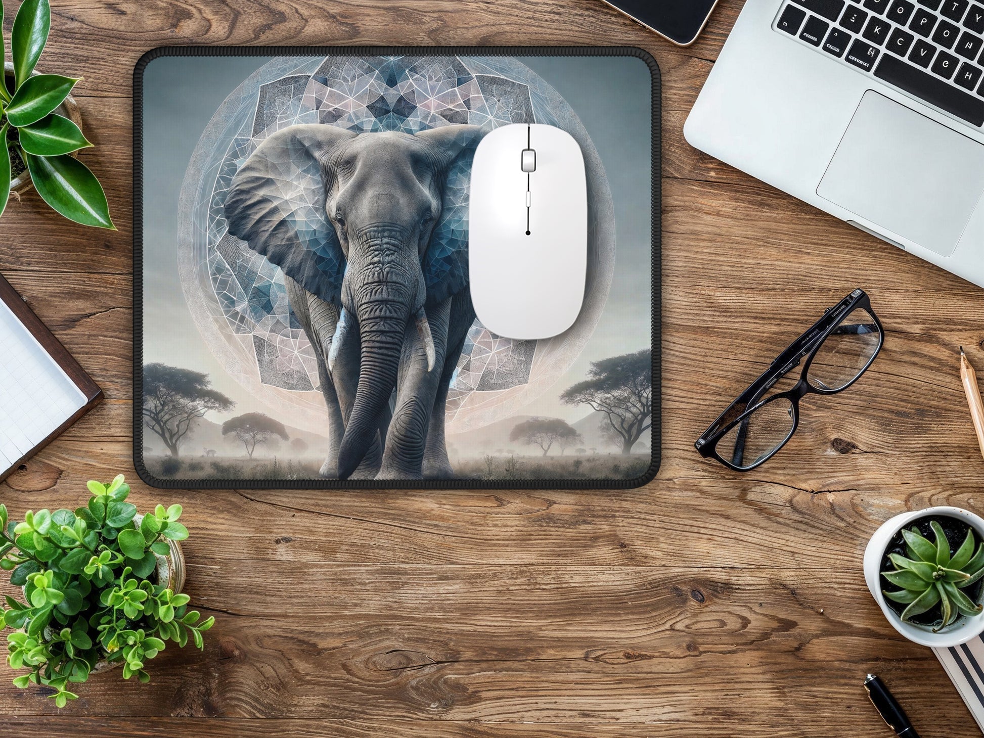 Workspace with wooden accents, complemented by the kaleidoscope elephant mouse pad, white mouse, and decorative plants.