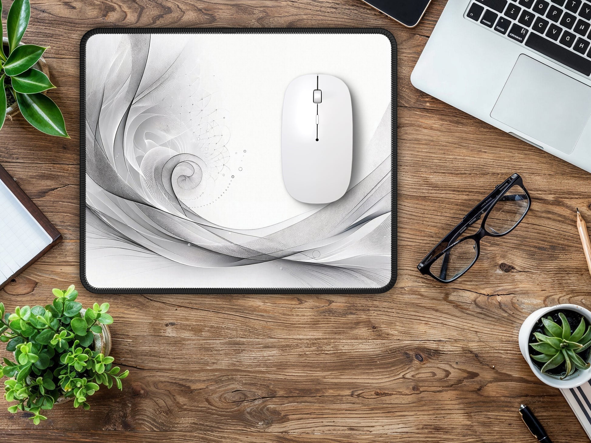 Bright and clean work area with the grayscale mouse pad design providing an elegant contrast on the wooden table.