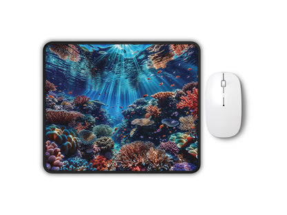 Vibrant mouse pad with a coral reef and marine life design, illuminated by rays of sunlight, alongside a sleek white mouse.