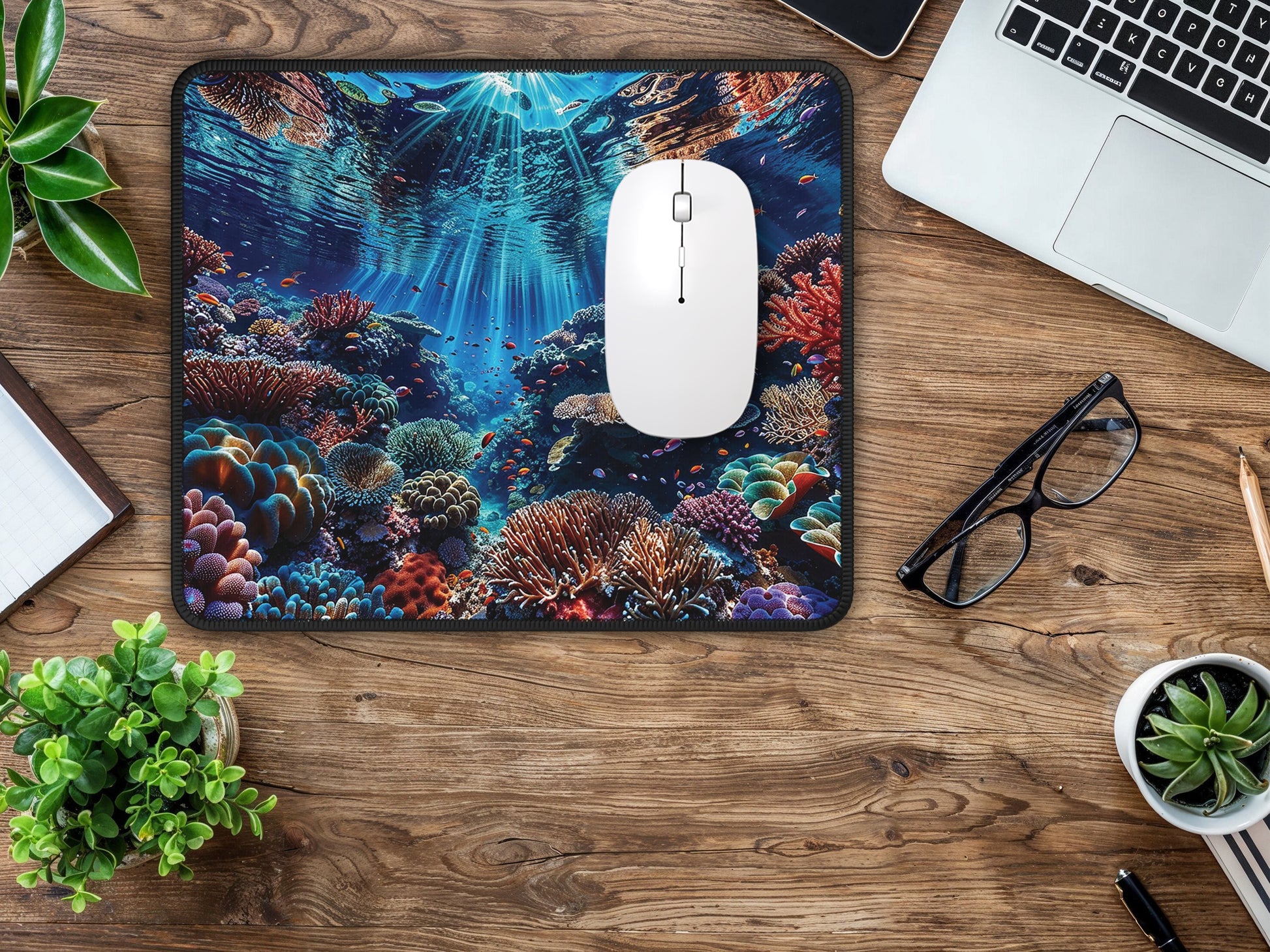 The mouse pad on a wooden surface surrounded by office tools, merging the oceanic vibe with productive workspace.