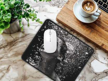 Mouse pad on a marble surface next to a white mouse and coffee cup, showcasing a womans face with water bubbles.